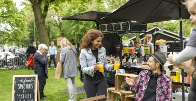 Markt met foodtruck en inwoners die gezellig aan een tafel zitten