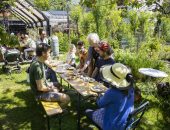 Bewoners Rotterdam zittend aan tafel in StadsOase de Spinozahof
